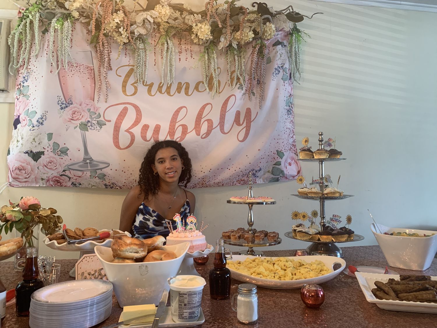Brunch and Bubbly printed backdrop above a dessert and brunch table