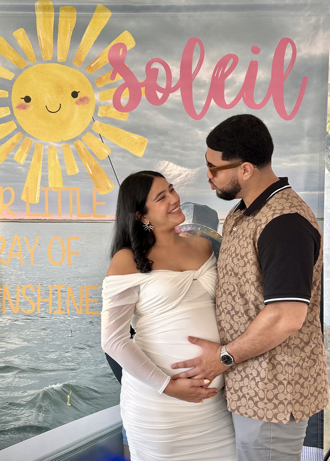 Couple at a Sunshine themed baby shower backdrop