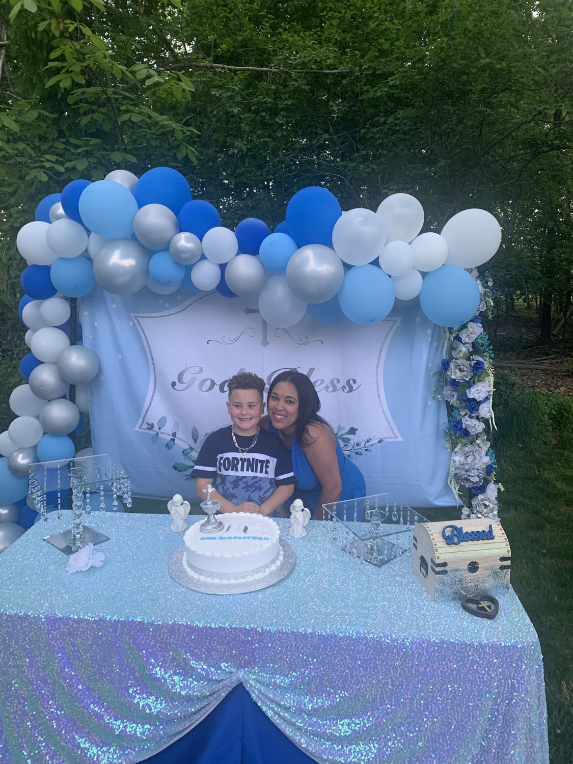 Blue, white and silver balloon arch behind a decorated birthday table