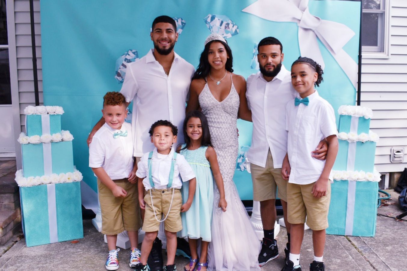 Family photo at a turquoise gift-box themed backdrop