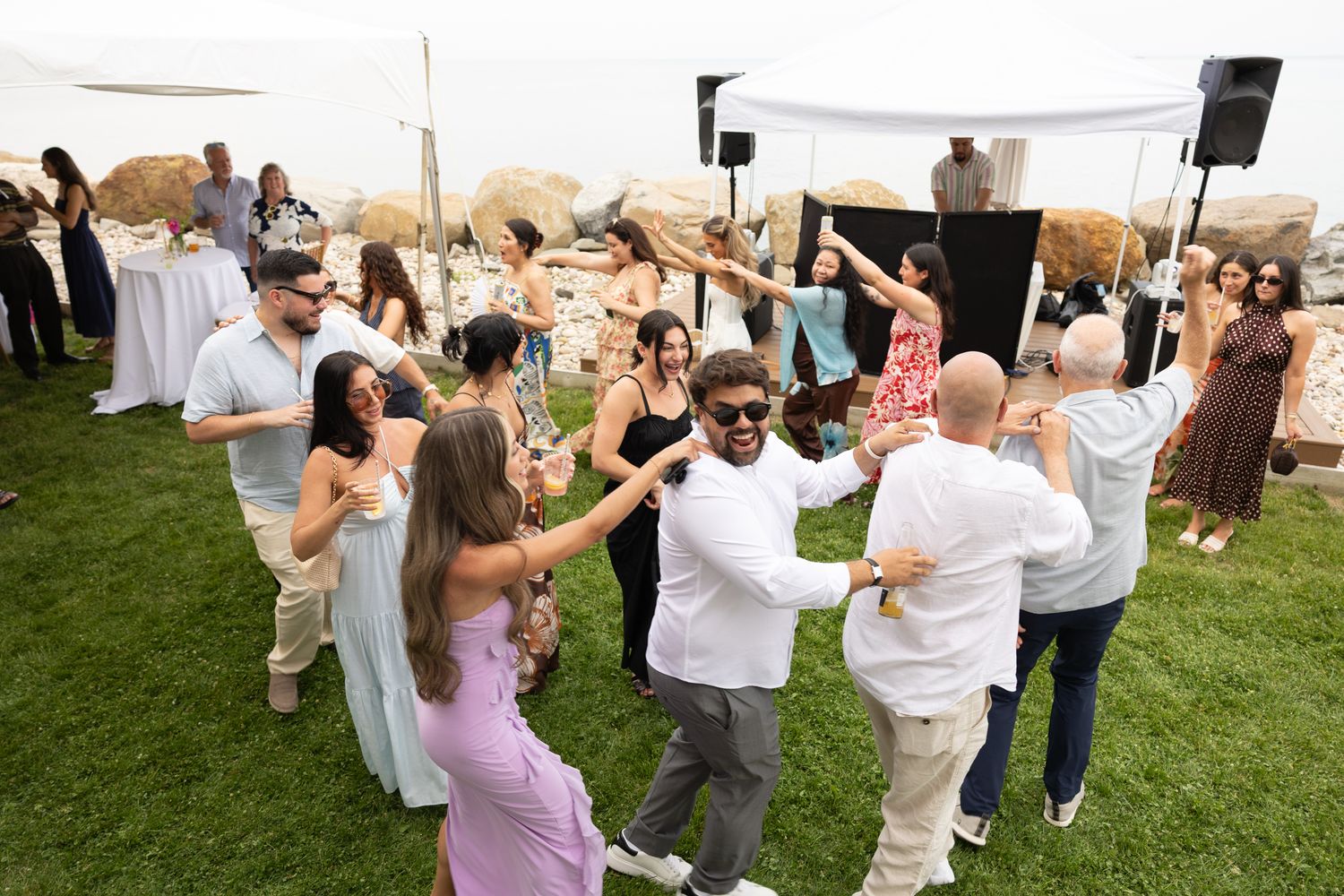 Guests dancing in a circle on the lawn near the DJ booth