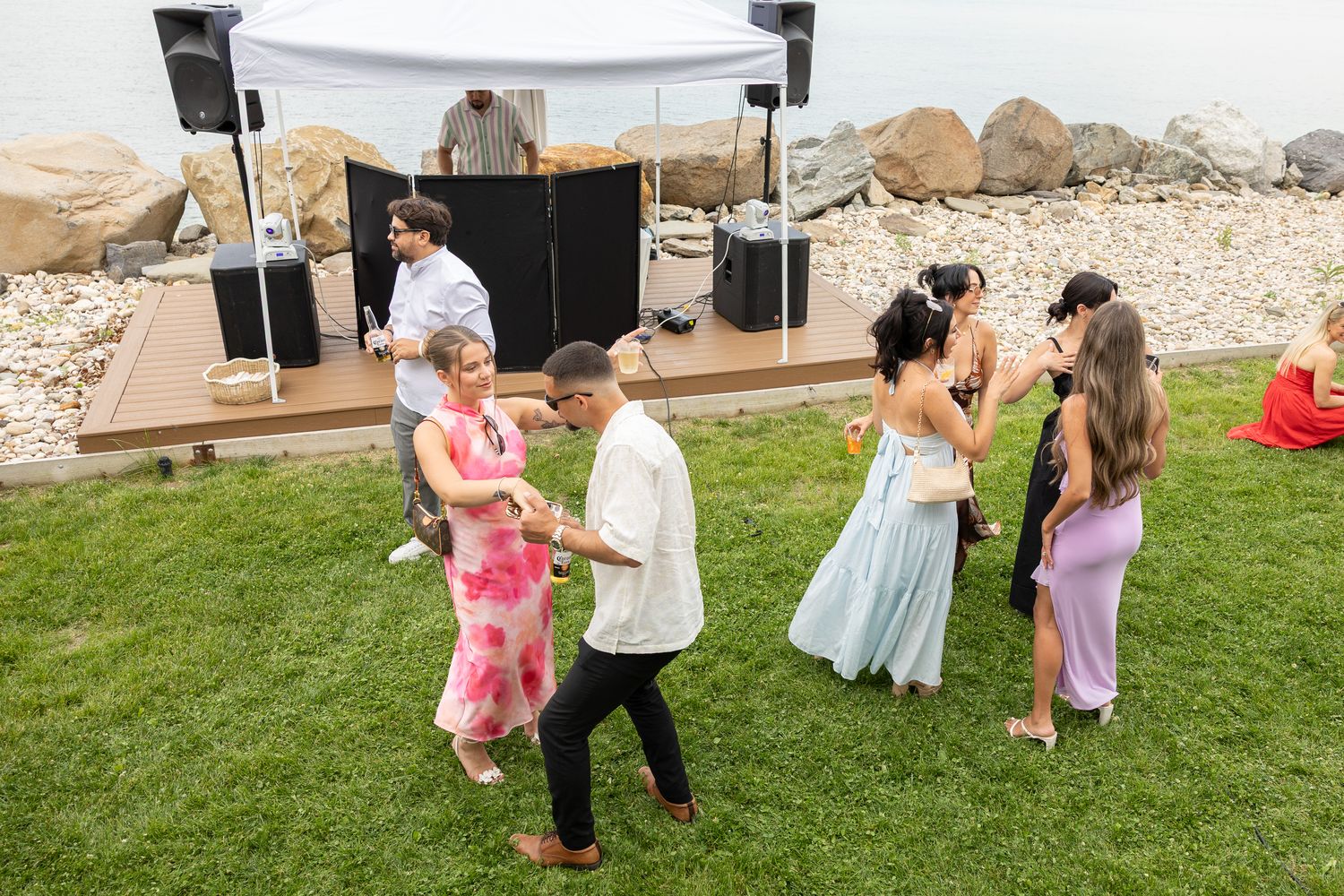 Guests dancing on the lawn at a waterfront bridal shower