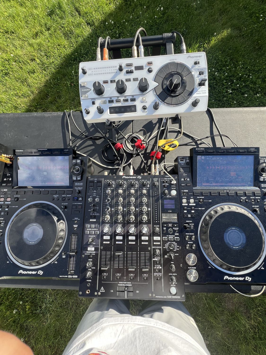Top-down view of Pioneer CDJs and a mixer set up outdoors