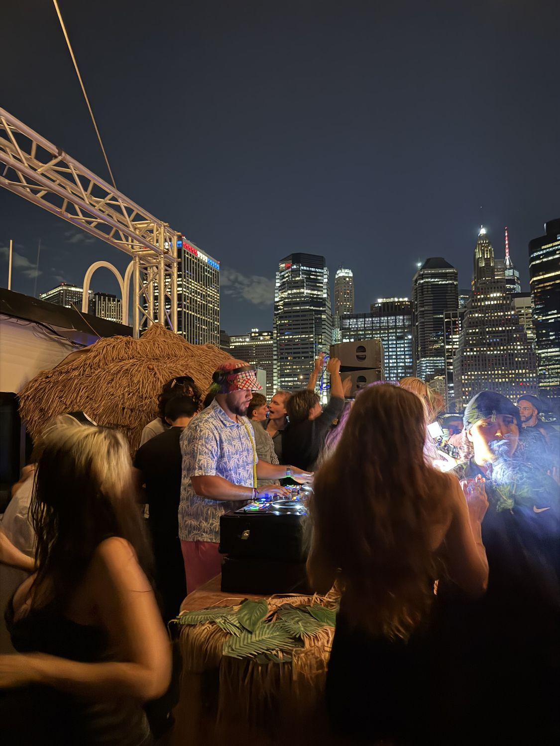 DJ and crowd with the New York skyline behind them