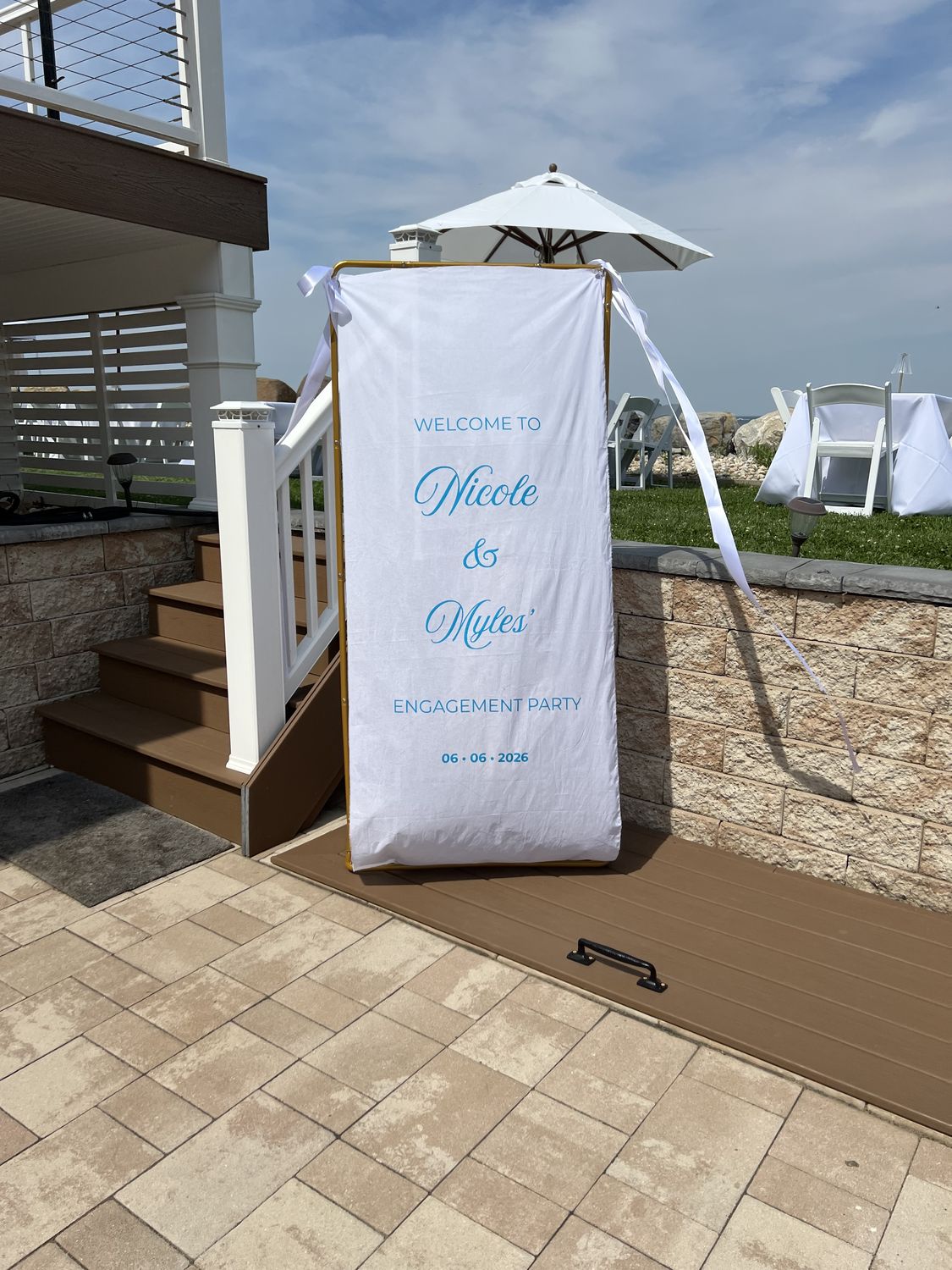 Custom welcome sign beside a patio umbrella at a celebration